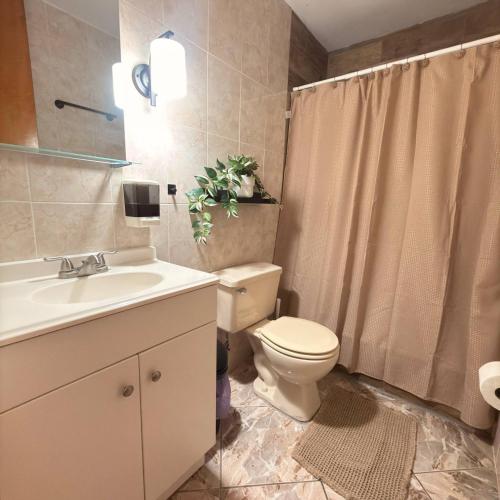 a bathroom with a toilet and a sink at Spacious 2BR Apt - Kitchen - Laundry - WiFi in Yauco