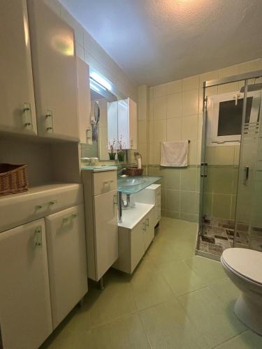 a white bathroom with a sink and a shower at Villa Fontes in Çeşme