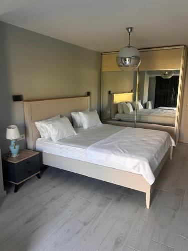 a bedroom with a large white bed and a mirror at Villa Fontes in Çeşme