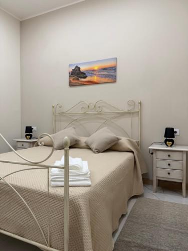 a bedroom with a bed and two tables and a painting at Catalano Suite Giada - Vista Mare in Palermo