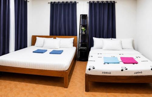 two beds sitting next to each other in a room at Nomads Retreat House in Moalboal