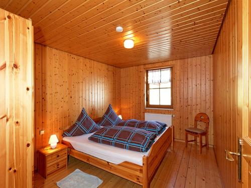 a bedroom with a bed in a wooden room at Glashof in Sankt Georgen im Schwarzwald