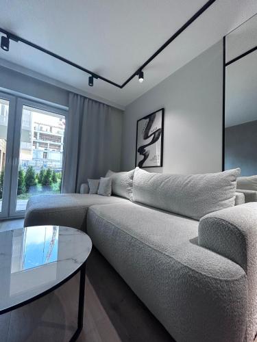 a living room with a couch and a table at Apartament z Tarasem Parking Smart TV Wi-Fi in Sosnowiec