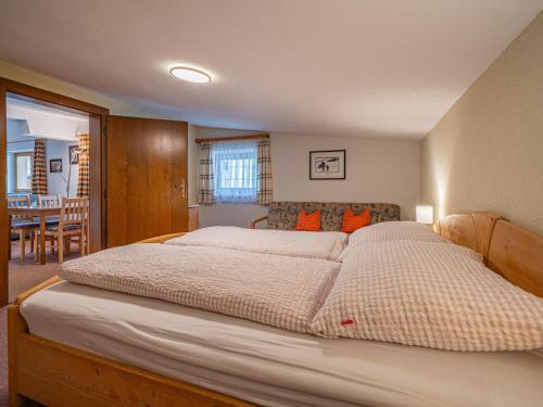 a bedroom with a large bed and a dining room at Das Bergnest Bergluft in Söll