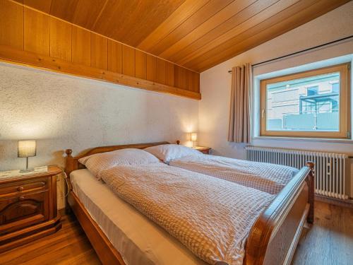 a bedroom with a large bed with a window and a bed sidx sidx at Das Bergnest Dorfglück in Söll