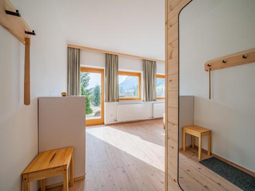 a room with a refrigerator and wooden floors and windows at Das Bergnest Heimatblick in Söll