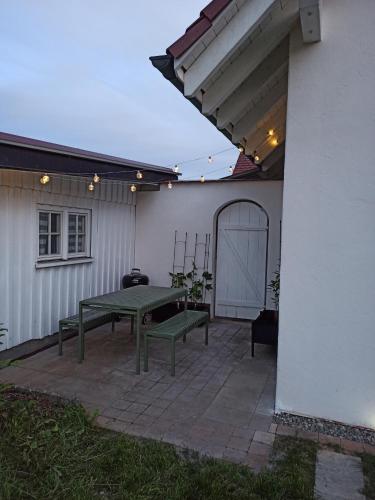 a patio with a green picnic table and a building at Ferienwohnung Reichenbach in Bad Schussenried