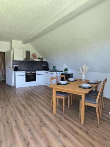 a kitchen and dining room with a wooden table and chairs at Ferienwohnung Reichenbach in Bad Schussenried