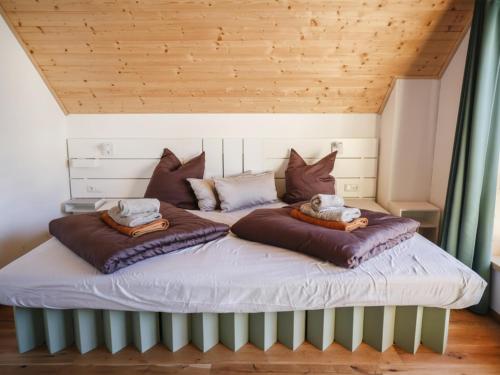 a bed in a room with two pillows on it at Chalet Gipfelduo in Ebene Reichenau