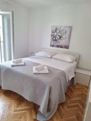 a bedroom with a bed with two towels on it at Apartment Stara Novalja 6375c in Novalja