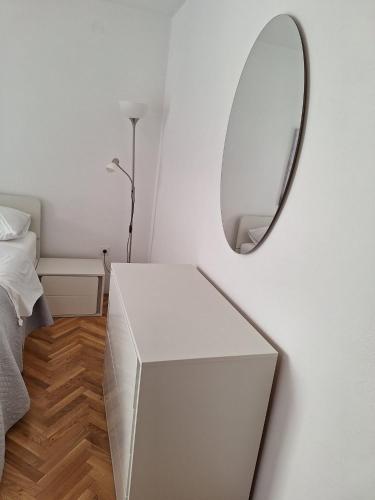 a white dressing table with a mirror next to a bed at Apartment Stara Novalja 6375c in Novalja