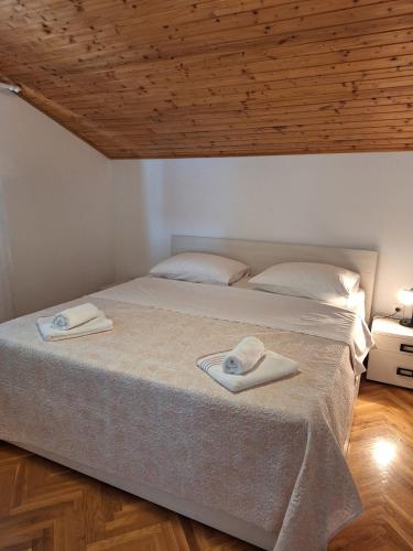 a bedroom with a bed with two towels on it at Apartments by the sea Stara Novalja, Pag - 6375 in Novalja