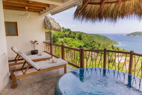 a balcony with a hot tub and a view of the ocean at Pacífica Grand Zihuatanejo in Zihuatanejo