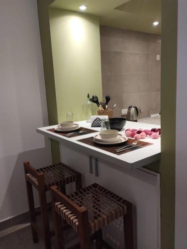 a kitchen with a island with two chairs and a counter top at JAZCA Huayco in San Salvador de Jujuy