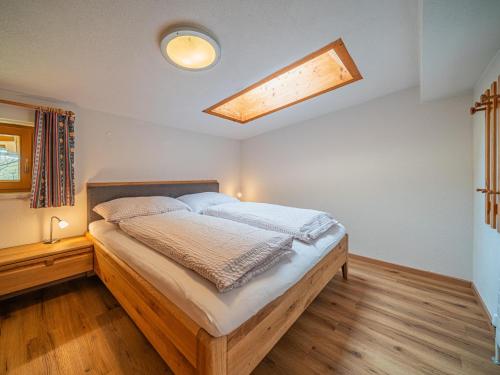 a bedroom with a wooden bed with a skylight at Das Bergnest Salvenblick in Söll
