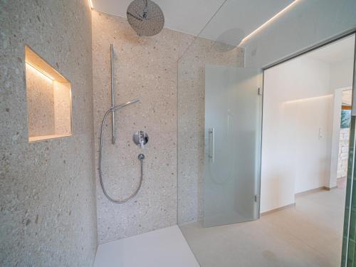a bathroom with a shower with a glass door at Das Bergnest Heimatblick in Söll