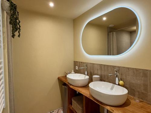 a bathroom with two sinks and a large mirror at Villaatje Veluwe in Garderen