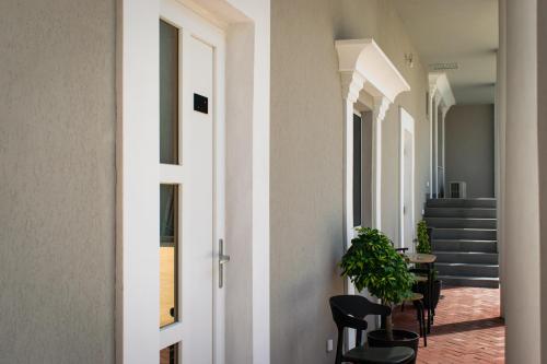 a corridor of a house with chairs and stairs at Pensiunea Ramedal in Calafat