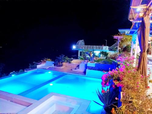 a swimming pool in the middle of a yard at night at Oceano con Vista Mountain Resort in Tagbaobo