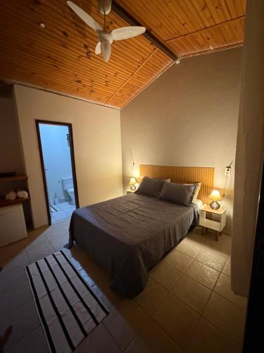 a bedroom with a bed and a ceiling fan at Pousada Caravelas in São Miguel do Gostoso