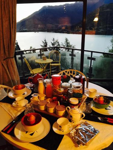 - une table avec des assiettes et de la vaisselle sur une table avec vue dans l'établissement Breakfast at Tiffanys, à Queenstown