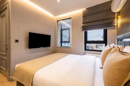 ein Schlafzimmer mit einem großen Bett und einem Flachbildfernseher in der Unterkunft The Revia Square Hotel in Istanbul