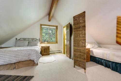 a attic bedroom with two beds and a window at 'Marble Hideaway' Cabin w/ Mountain Views + Deck! in Marble