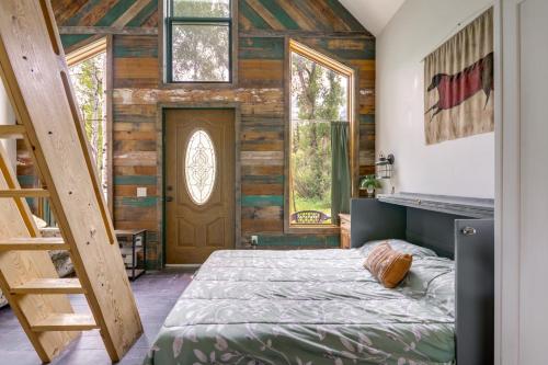 a bedroom with a bed and a wooden wall at Colorful Cabin w/ Teepee, Fire Pits & Mtn Views! in Marble