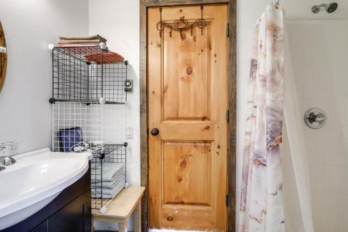 a bathroom with a sink and a wooden door at Colorful Cabin w/ Teepee, Fire Pits & Mtn Views! in Marble