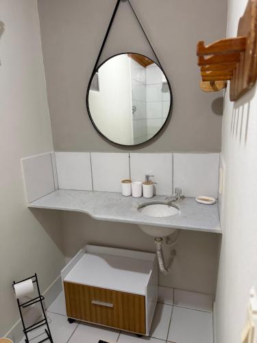 a bathroom with a sink and a mirror at Pousada Caravelas in São Miguel do Gostoso