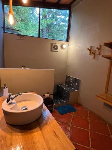 a bathroom with a sink in a room with a window at Los Cruxes in Tepoztlán