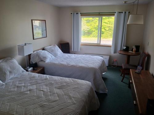 a hotel room with two beds and a window at Chapel Hill Motel in Moran