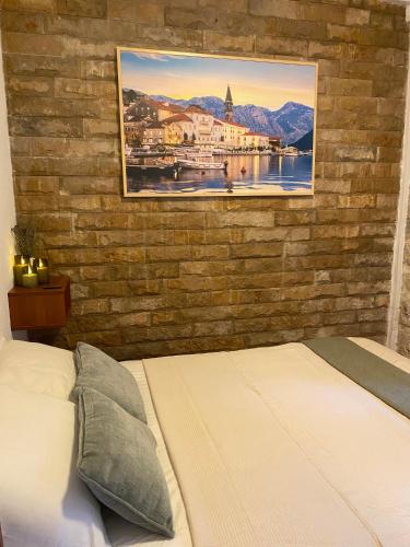 a bedroom with a brick wall with a bed at Charming Stone Cottage Kotor in Kotor
