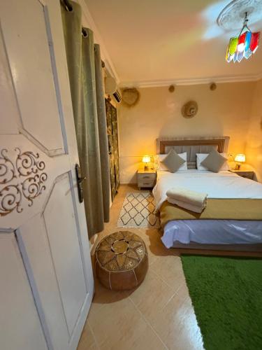 a bedroom with two beds and a door at Riad dar sahrawi in Marrakesh