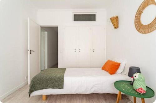 a bedroom with a bed and a green chair at Casa da Matilde in Estoril