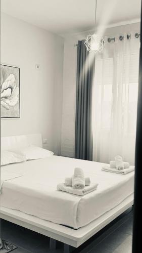 a bedroom with a bed with towels on it at Todhe Apartment - Gjiri Lalezit 500m from the beach in Draç