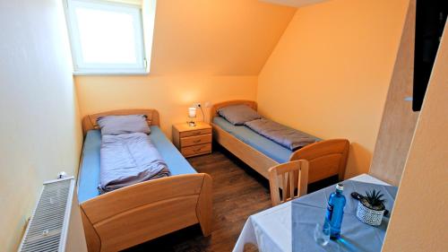 a small room with two beds and a table at Gasthaus Schwarzer Adler in Holzgünz