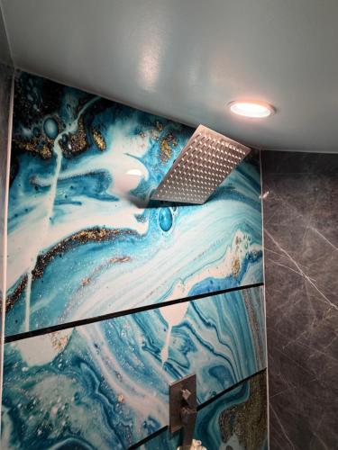 a painting on the wall of a bathroom with a laptop at Sip and Soak, hotel-style room in Calgary