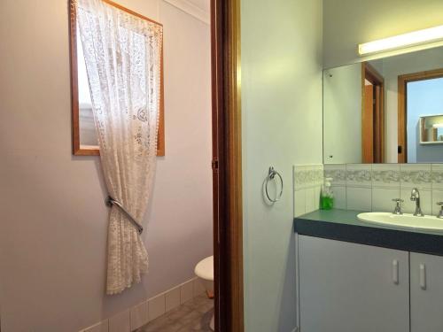 a bathroom with a sink and a toilet and a mirror at Dolphin Cove in Wallaroo