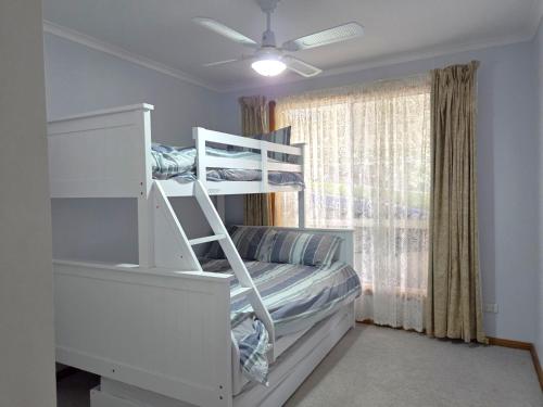 a bedroom with two bunk beds and a window at Dolphin Cove in Wallaroo