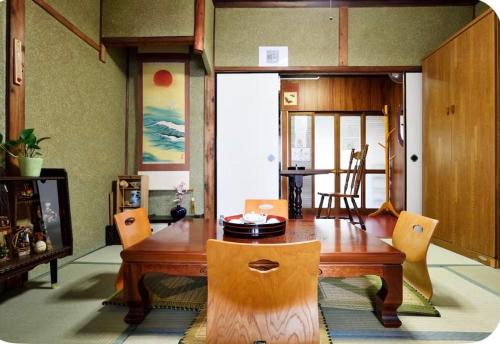 a dining room with a wooden table and chairs at 2 floors japanese style, direct to KIX, 10mins train to Namba, 5mins walk to stn , 2-6ppl in Osaka