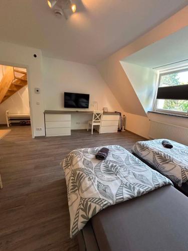 a bedroom with two beds and a tv in it at Ferienwohnung am Uniklinik in Lübeck