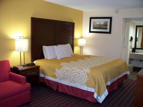 a hotel room with a bed and a red chair at Bluegrass Inn in Frankfort