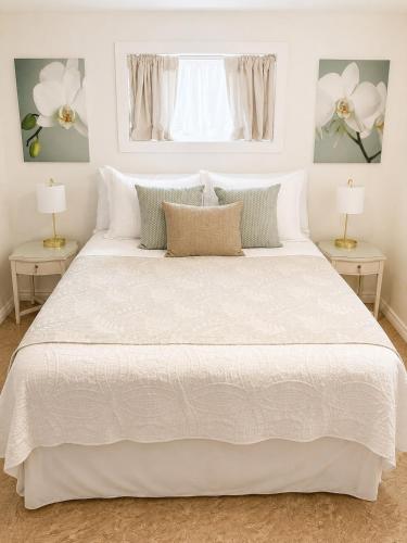 a bedroom with a large white bed with two lamps at The Bunny Street Getaway! in Kenora