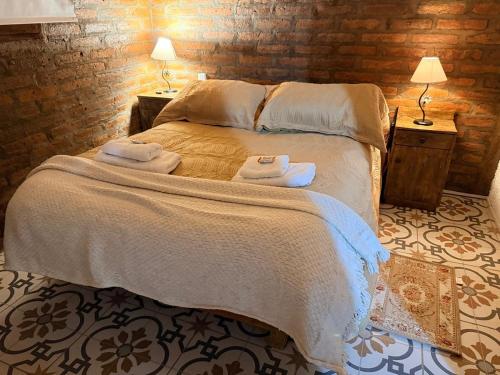 a bedroom with a bed with towels on it at Alojamiento en Barreal, San Juan in Barreal