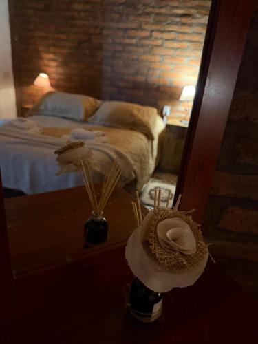 a hat sitting on a table in front of a mirror at Alojamiento en Barreal, San Juan in Barreal