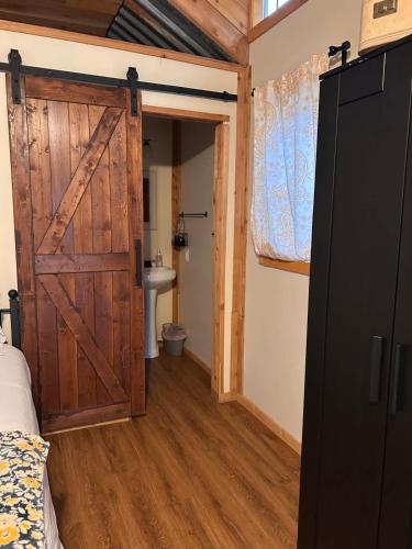 a barn door in a room with a bathroom at Hill Country Cabin 1 in Canyon Lake