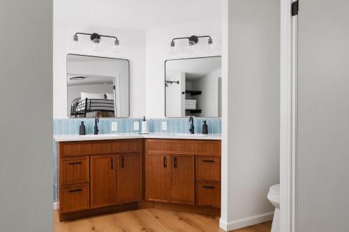 a bathroom with a sink and two mirrors at Sun & Sand Resort in Port Austin