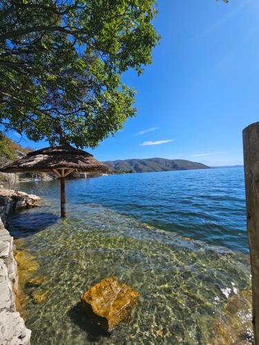 an umbrella in the water next to a body of water at Velas del Lago in Piedras Moradas