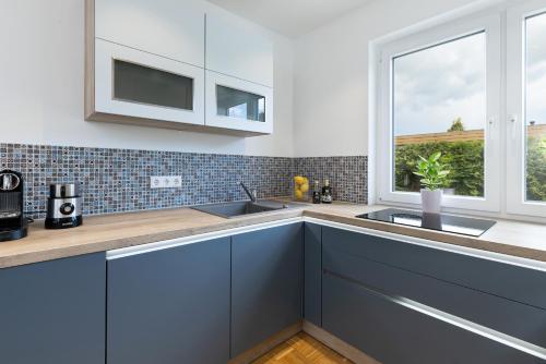 a kitchen with blue cabinets and a window at Treibholz in Schönberg